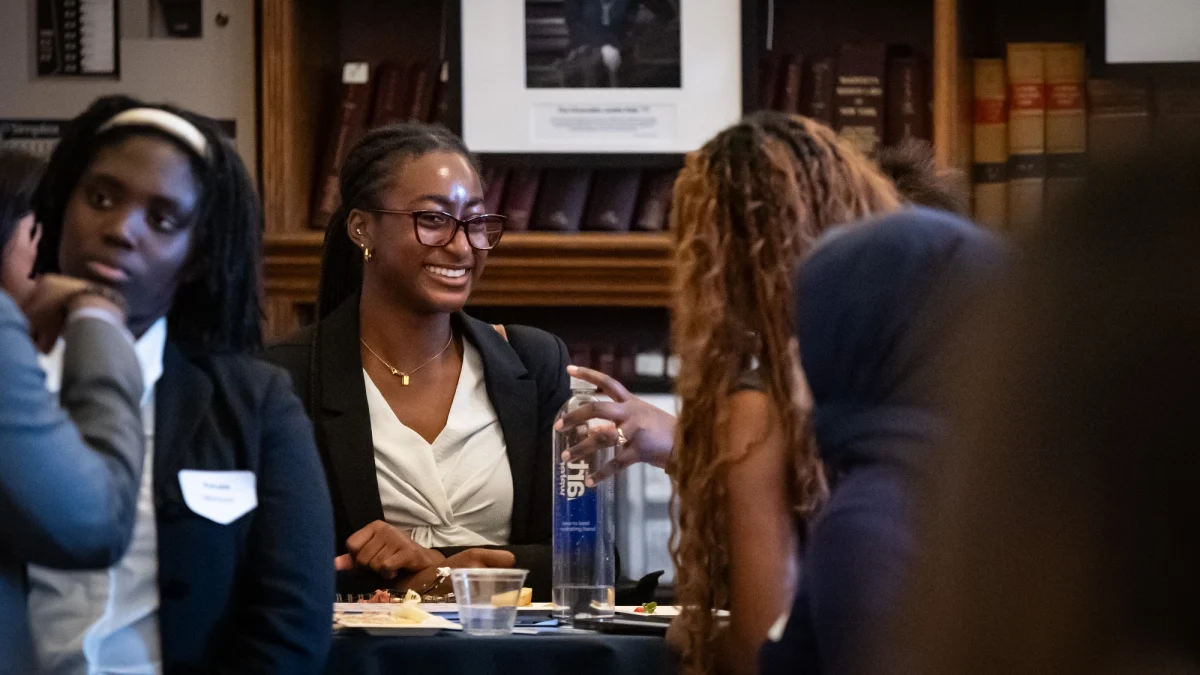 UConn students conversing and smiling at each other.