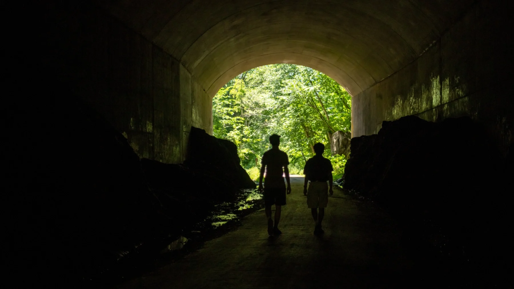 Students walking through dark tunnel.