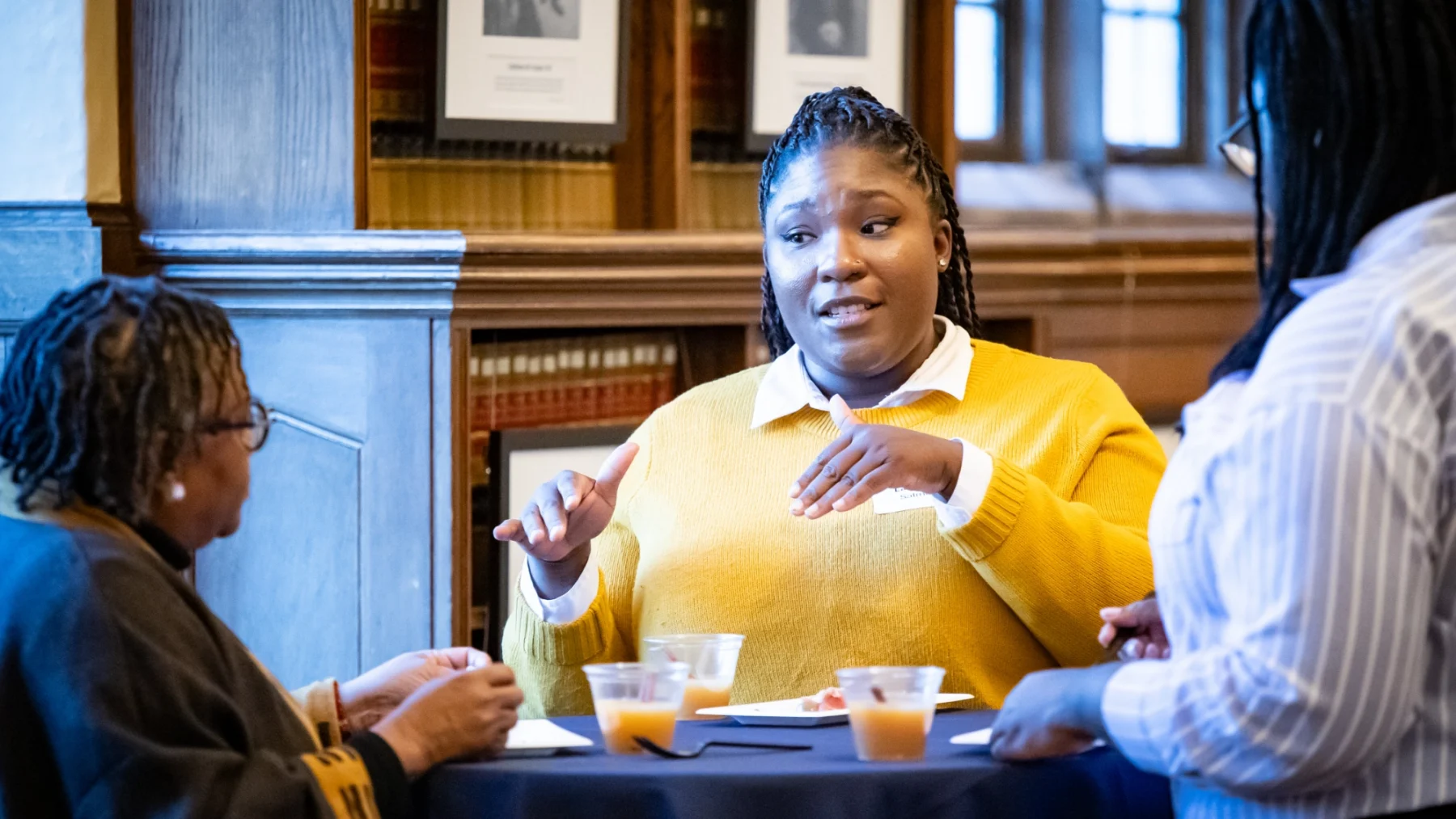 Woman of color speaking with other woman.